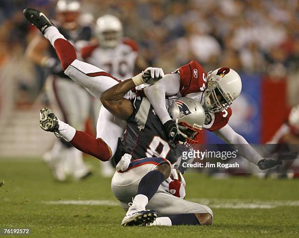 Patriots' Benjamin Watson is brought down by Robert Griffith of the Cardinals during a preseason game between the New England Patriots and the the...