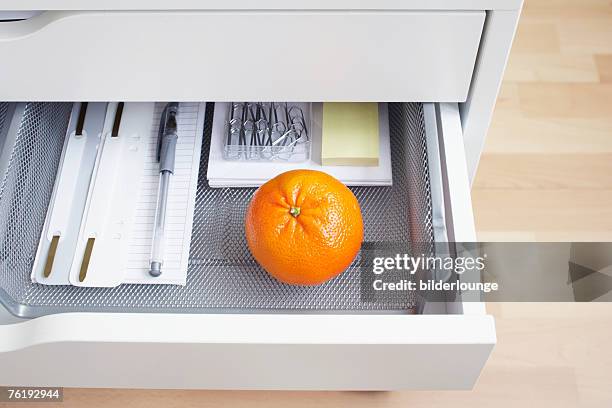 view into open desk drawer containing one orange - drawer bildbanksfoton och bilder