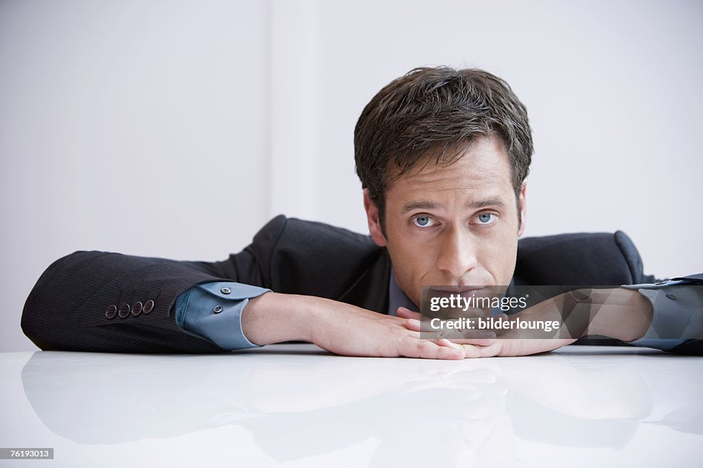 Portrait of sad businessman sitting at table