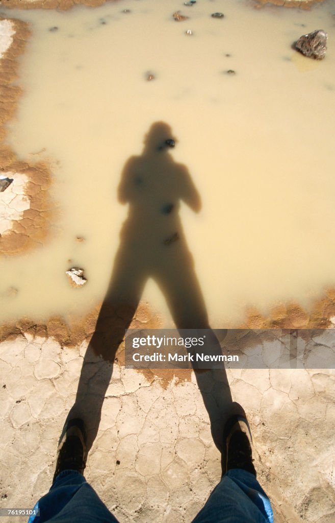 Person's shadow in puddle, Amboy Crater Natural Area, Mojave Desert, California, United States of America, North America