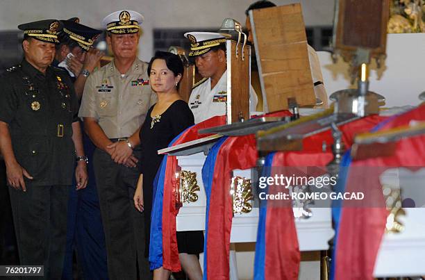 Philippine President Gloria Arroyo accompanied by top military offiicials pay her last respects to the 16 soldiers killed in fighting against the Abu...