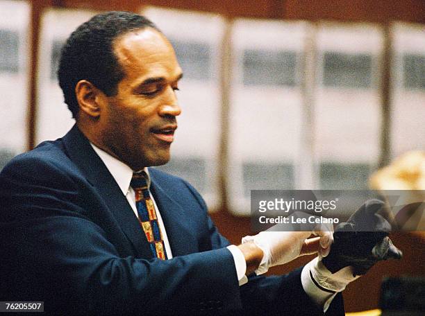 Simpson tries on a leather glove allegedly used in the murders of Nicole Brown Simpson and Ronald Goldman during testimony in Simpson's murder trial...