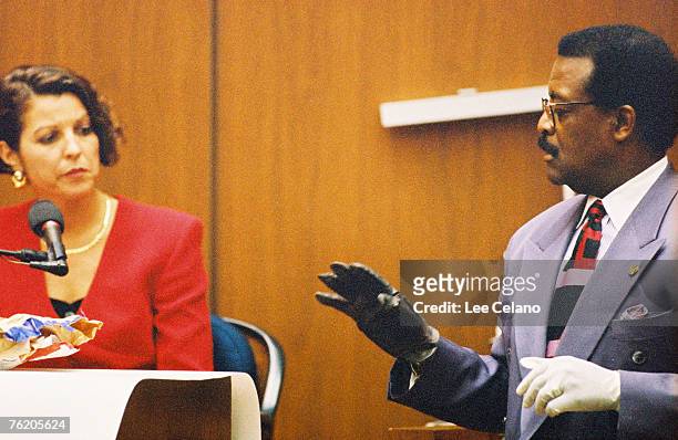 Defense attorney Johnnie Cochran questions Brenda Vemich, a buyer for Bloomingdale's, as he wears a leather glove allegedly used in the murders of...