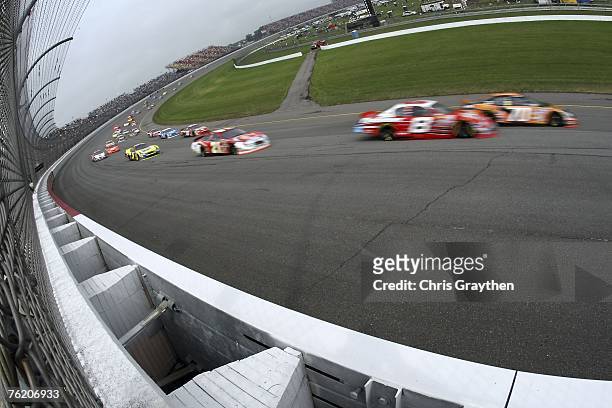 Johnny Sauter, driver of the Yellow Transportation Chevrolet, races Dale Earnhardt Jr., driver of the Budweiser Chevrolet, and Bill Elliott, driver...