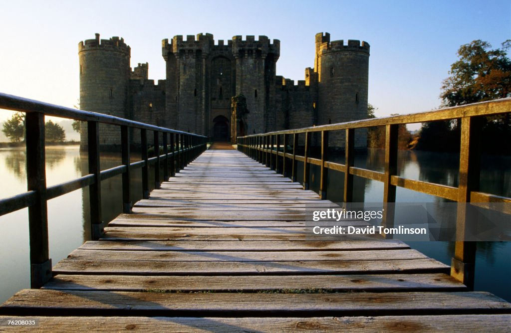 Wooden bridge across the moat at Bodiam Castle, early morning, Eastbourne, East Sussex, England, United Kingdom, Europe