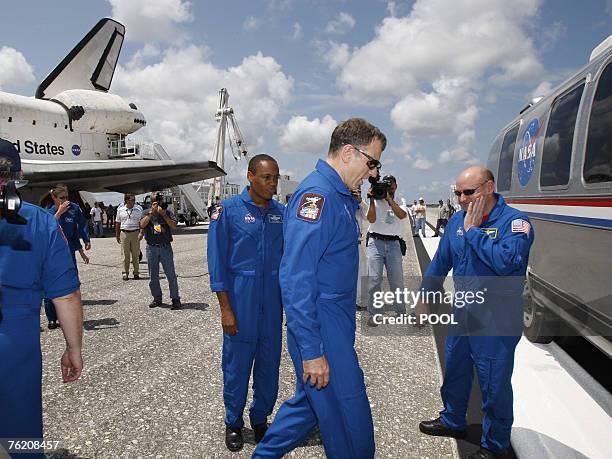 Canadian Space Agency's Dafydd R. Williams , mission specialist Alvin Drew Jr. And Commander Scott J. Kelly stand outside a waiting van after the...