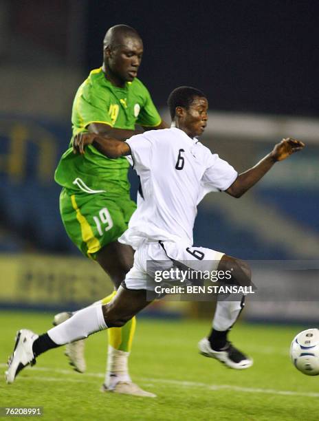 Senegalese football player Papa Bouba Diop tackles Ghana's Anthony Annan during their international friendly football match at the Den stadium in...