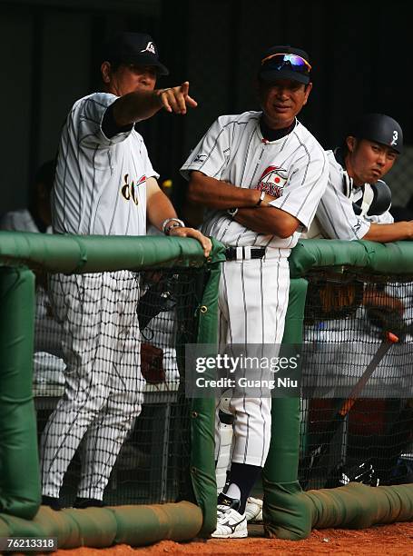 Japanese baseball team's manager Senichi Hoshino and coach Koji Yamamoto chat during a match against France in the Good Luck Beijing baseball...