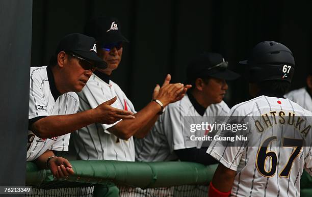 Japanese baseball team manager Senichi Hoshino and coach Koichi Tabuchi watch a match against France in the Good Luck Beijing baseball tournament at...