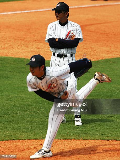 Japanese baseball team pitching coach Yutaka Ono watches his player Ryuji Wakatake throwing a ball during a match against France in the Good Luck...