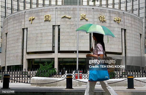 Pedestrian walks past the People's Bank of China, also known as China's Central Bank in Beijing, 22 August 2007. China's bid to tighten liquidity...