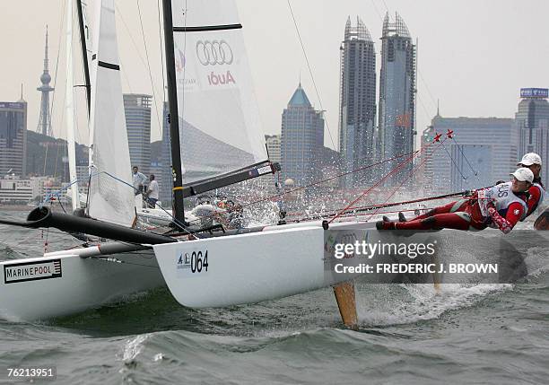 Australia's Glenn Ashby and Darren Bundock manoeuver their vessel on way to winning silver in the Tornado sailing medal race, 22 August 2007, in...