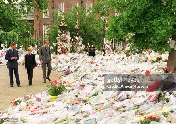 Prince William, Prince of Wales, with his sons Princes William and Harry looking at floral tributes left at Kensington Palace following the death of...