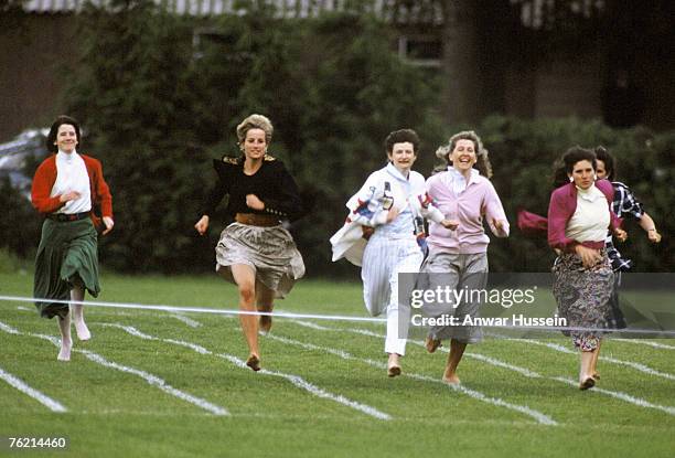 Diana, Princess of Wales, runs barefoot as she takes part in the Mother's race during Prince Harry's school sports day in Richmond on June 11, 1991...