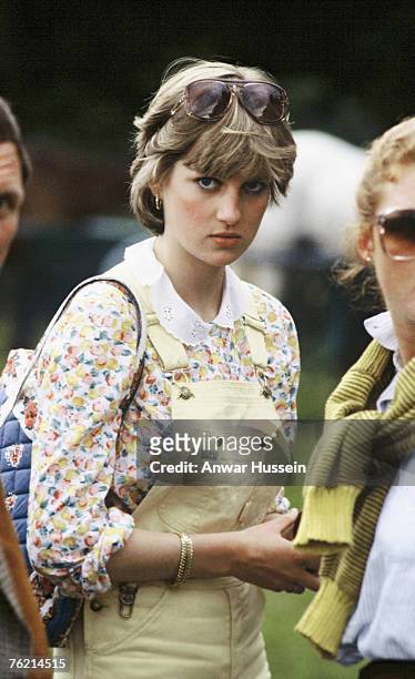 Lady Diana Spencer, wearing yellow dungarees with a floral blouse and red wedges, attends a polo match at Cowdray Park Polo Club on July 12, 1981 in...