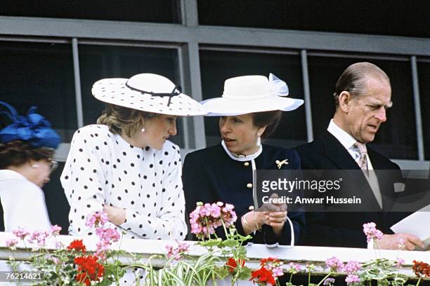 Diana, Princess of Wales, wearing a dress by Victor Edelstein and hat by Frederick Fox, chats with Princess Anne, Princess Royal and Prince Philip,...