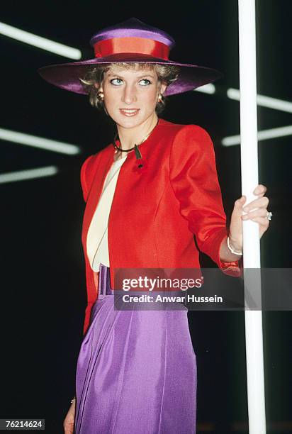 Diana, Princess of Wales, wearing a red and purple suit designed by Catherine Walker with a matching hat and remembrance poppy, arrives on the...