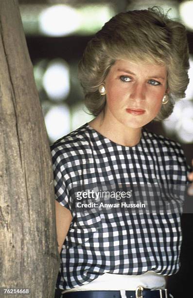 Diana, Princess of Wales, wearing a black and white check top with cap sleeves and a white pencil skirt and black belt designed by Alistair Blair, on...