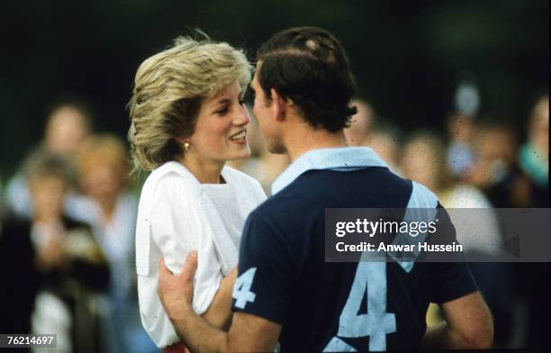 Prince Charles, Prince of Wales and Diana, Princess of Wales, wearing a white blouse, embrace during a polo match at Cirencester Park Polo Club on...
