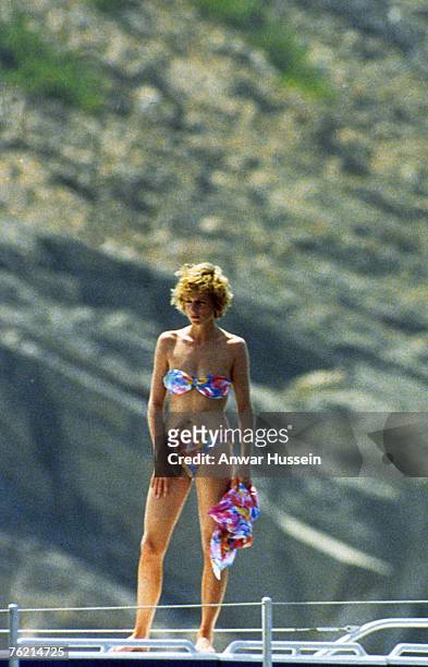 Diana, Princess of Wales, wearing a patterned bikini and holding a matching sarong, stands on board a yacht, whilst on holiday on August 16, 1988 in...
