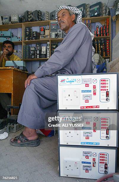 An Iraqi man sits by electrical appliances converting direct to alternating current at Agd al-Nasara market, specialized in selling electricity...