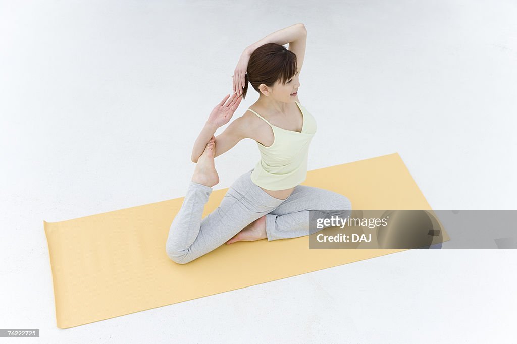 A Young Woman Practicing Yoga, Sitting and Putting Her Arms Behind the Head, High Angle  View