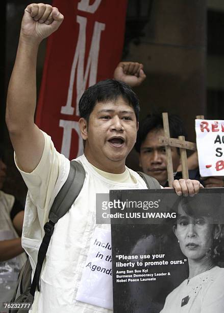 Protester holds a photograph of detained Myanmar opposition leader Aung San Suu Kyi as he shouts slogans during a demonstration at the Myanmar...