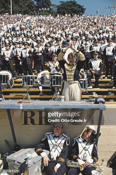 Two members of the University of California, Berkeley marching band sleep as the rest of the band and spectators cheer on the California Golden Bears...