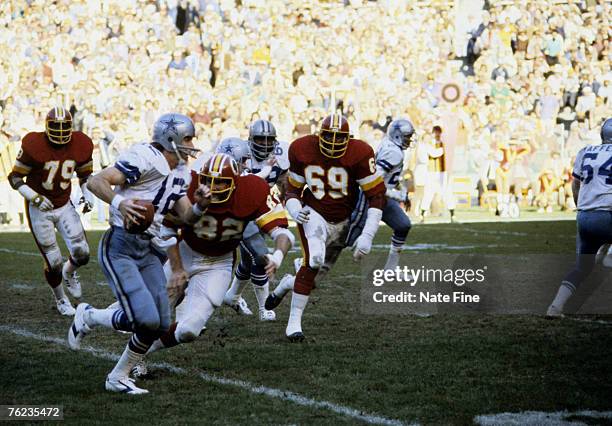 Hall of Fame quarterback Roger Staubach of the Dallas Cowboys rolls out and tries to elude Redskins defensive end Dallas Hickman during the Cowboys...