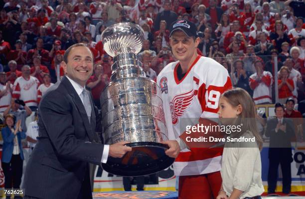 Commissioner Gary Bettman presents Steve Yzerman of the Detroit Red Wings with the Stanley Cup after his team defeated the Carolina Hurricanes 3-1 in...