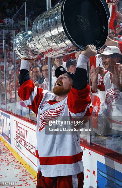 Kris Draper of the Detroit Red Wings hoists the Stanley Cup after defeating the Carolina Hurricanes 3-1 in game five of the NHL Stanley Cup Finals on...