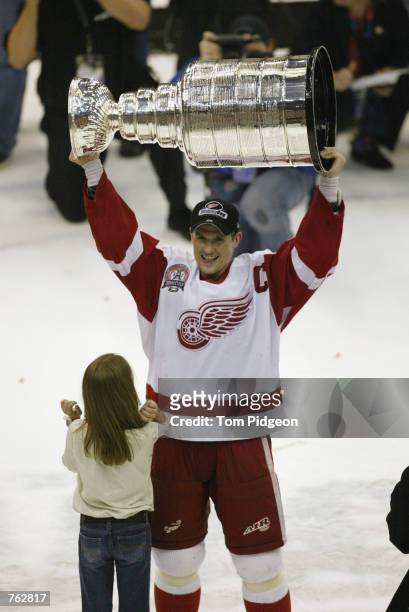 Steve Yzerman of the Detroit Red Wings and his daughter Isabella celebrate with the Stanley Cup trophy after defeating the Carolina Hurricanes during...