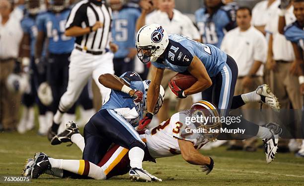 Reed Doughty of the Washington Redskins tackles Cortland Finnegan of the Tennessee Titans during a preseason game on August 11, 2007 at LP Field in...