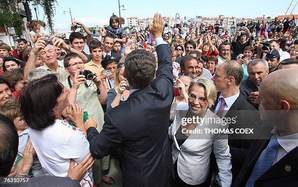 French president Nicolas Sarkozy , flanked by Interior Minister Michele Alliot-Marie waves to the crowd before having lunch in the French Basque city...