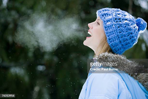 young woman wearing winter hat, laughing, outdoors - zichtbare adem stockfoto's en -beelden