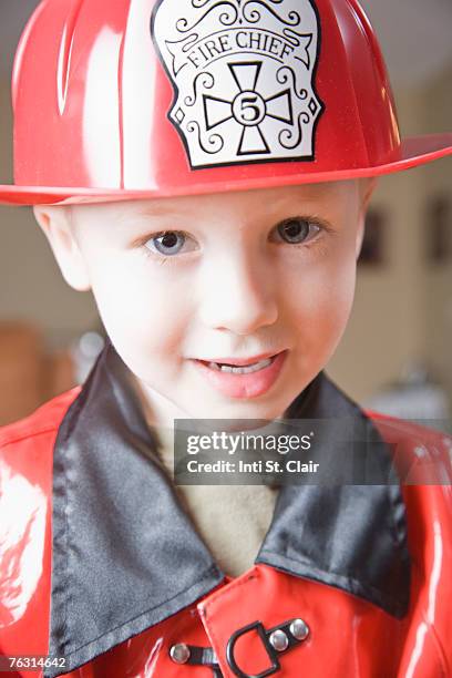 boy (3-4) wearing firefighter's costume, portrait, close-up - boy fireman costume stock pictures, royalty-free photos & images