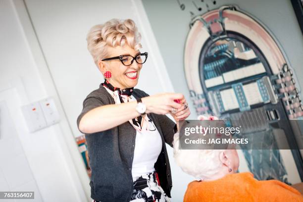 woman working in quirky hair salon - vintage beauty salon stock pictures, royalty-free photos & images