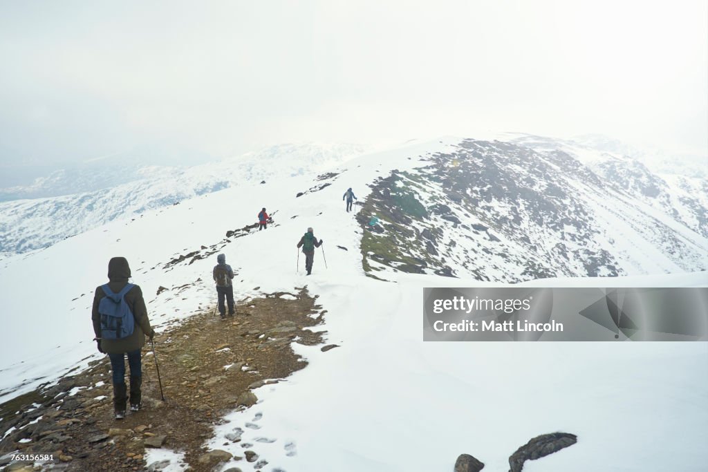 Hikers on snow-covered mountain, Coniston, Cumbria, United Kingdom