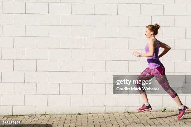 young female runner running along sidewalk - live at leeds 2016 stock pictures, royalty-free photos & images