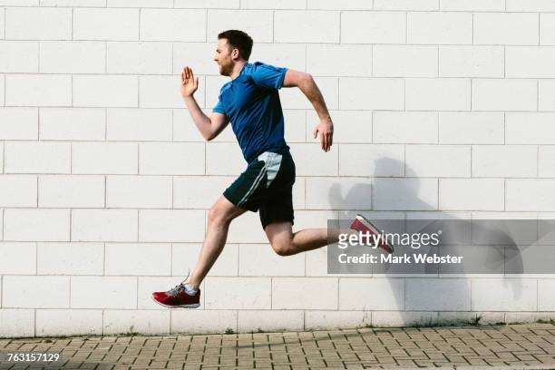 young male runner speed running along sidewalk - live at leeds 2016 stock pictures, royalty-free photos & images