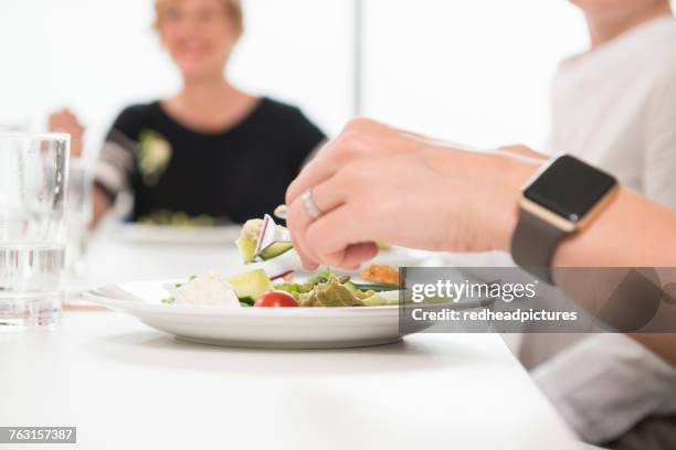 businesswomen at working lunch in office - business lunch stock pictures, royalty-free photos & images