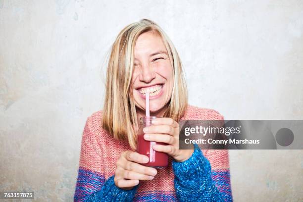 portrait of woman drinking smoothie, smiling - straw fotografías e imágenes de stock