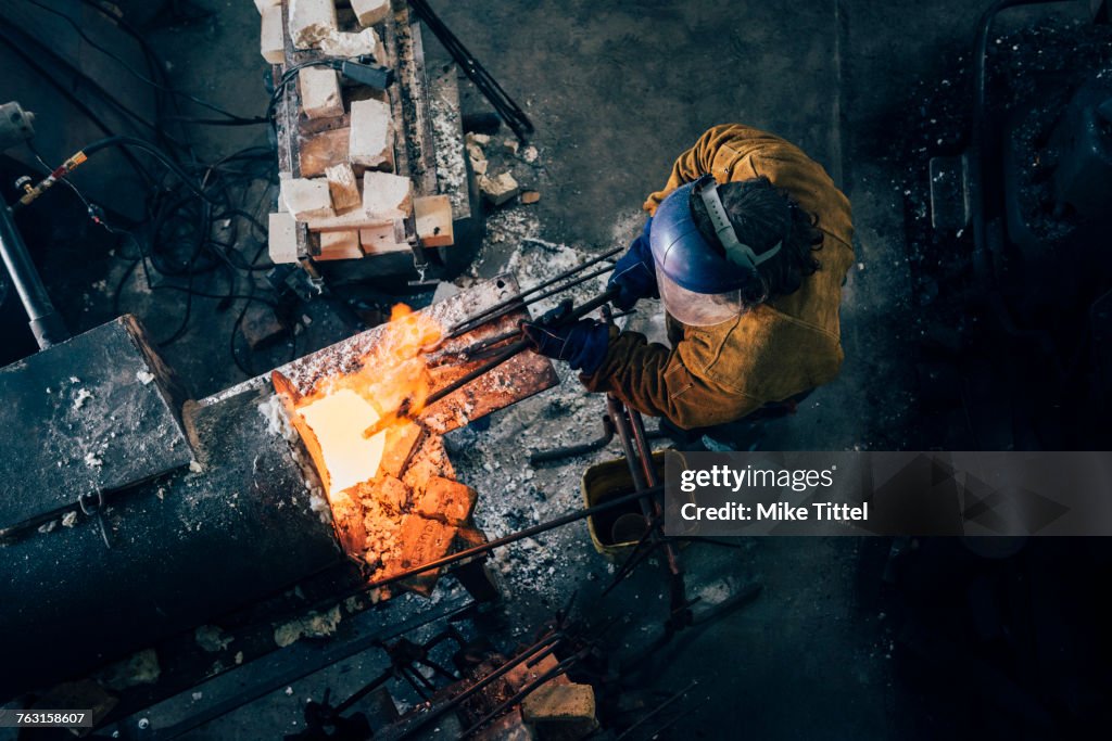 Temperature Red Overhead View Of Blacksmith Shaping Red Hot Metal Rod In Workshop ...