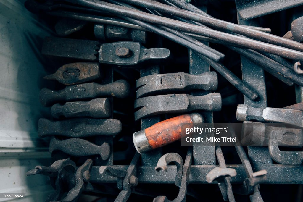Overhead view of blacksmith tongs and hammers in workshop