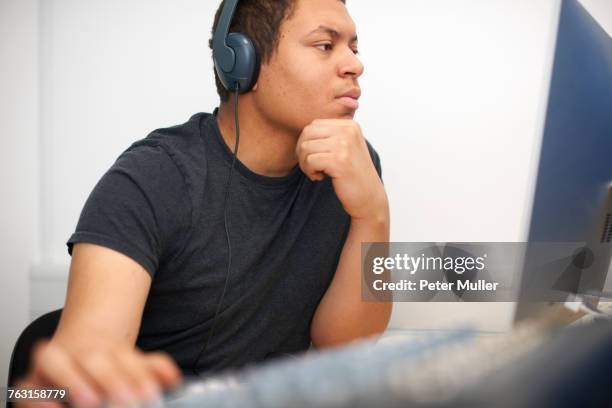 young male college student at mixing desk in tv studio - post production house stock pictures, royalty-free photos & images