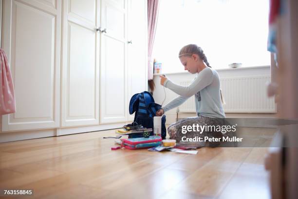 girl kneeling on floor packing school bag - satchel stock pictures, royalty-free photos & images