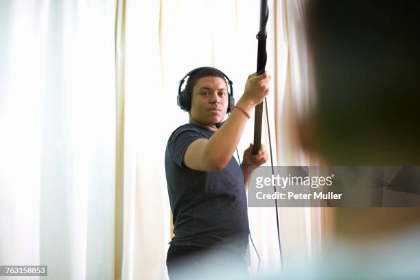 young male college student recording in tv studio - mikrofonhållare bildbanksfoton och bilder
