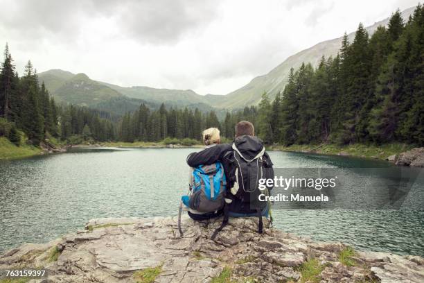 rear view of couple hiking, sitting by lake, tirol, steiermark, austria, europe - styria stock-fotos und bilder