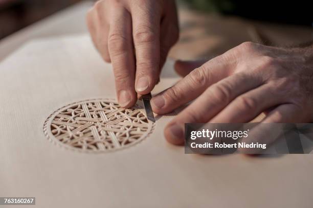 lute manufacturer carving out ornament out of wood - arabic lutes stock pictures, royalty-free photos & images