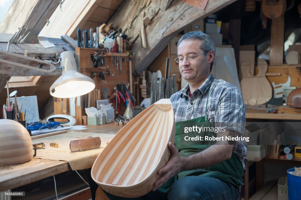 Craftsman manufacturing lute at workshop